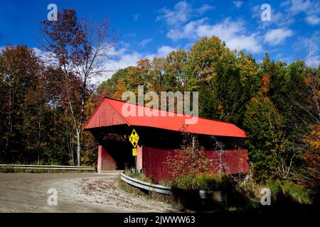 An einem schönen Herbsttag wurde eine überdachte Brücke auf einer Landstraße in der Nähe von Stowe, Vermont, USA, gefunden Stockfoto