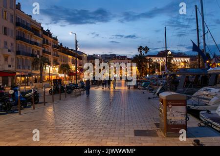 Blick auf die Marina in Cannes bei Nacht. Menschen gehen. Stockfoto