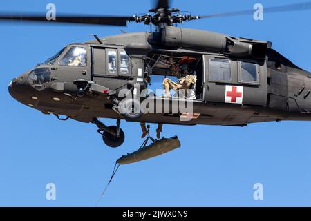 Am 28. August 2022 führt eine dem Yakima Training Center der US-Armee zugewiesene Luftbesatzung einen Hebezeug eines simulierten SKED-Wurfpatienten mit Mitgliedern der Central Washington Mountain Rescue im Yakima Training Center, Washington, durch. (USA Foto der Armee von Capt. Kyle Abraham, 16. Combat Aviation Brigade) Stockfoto