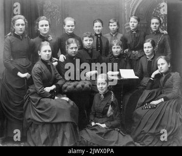 Klasse 8, Höhere Mädchenschule. Im Frühjahr 1887. Klassenoffizierin Miss Hanna Rehnström. Die obere Reihe von links: Tekla Swedlund, Gerda F. Fanny Liljedahl, Sofia Holmdahl, Hulda Björkman, Alma Lindahl und Ingrid Wiklund. Von links sitzend Sigrid Paues, Olga Modin, Maria Åkeerson, Gestna Blickert, Helna Berndtsson und Ebba Reuterskiöld. Auf dem Boden Maria von Friesen. Klass 8, Högre Flickskolan. Våren 1887. Klassföreståndarinna Fröken Hanna Rehnström. Övre raden från Sänger: Tekla Swedlund, Gerda F. Fanny Liljedahl, Sofia Holmdahl, Hulda Björkman, Alma Lindahl und Ingrid Wiklund. Sittandes frå Stockfoto