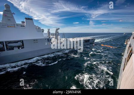 220904-N-PC065-1127 OSTSEE (SEPT 4, 2022) – die Royal Netherlands Navy Multi-Mission Support-Schiff HNLMS Karel Doorman (A833), links, und US Navy San Antonio-Klasse amphibischen Transport Dock Schiff USS Arlington (LPD 24) führen Auffüllung-at-Sea Training in der Ostsee, 4. September 2022. Die Arlington ist Teil der Kearsarge Amphibious Ready Group und die 22. Marine Expeditionary Unit unter dem Kommando und der Kontrolle der Task Force 61/2 befindet sich im geplanten Einsatzgebiet der US Naval Forces Europe, das von der US Sixth Fleet zur Verteidigung der Interessen der USA, der Alliierten und der Partner eingesetzt wird. ( Stockfoto