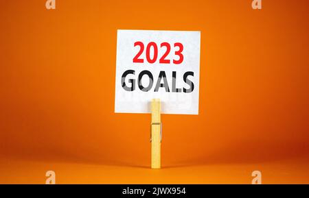 Symbol für 2023 Tore. Weißes Papier mit den Worten 2023 Tore, Clip auf Holz Wäschestift. Schöne orange Tisch orange Hintergrund. Business und 2023 Ziele kontra Stockfoto