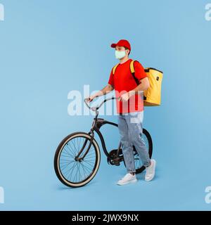 Deliveryman Trägt Gesichtsmaske Stehen Mit Fahrrad Über Blauem Hintergrund Stockfoto