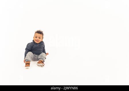 Süßer afroamerikanischer kleiner Junge mit einem gefälschten Schnurrbart, mittellange Nahaufnahme, isoliert im Studio. Hochwertige 4K-Aufnahmen Stockfoto