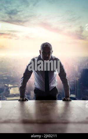 Er hat seine Stadt auf die Landkarte gesetzt. Zugeschnittenes Porträt eines reifen Geschäftsmannes, der in seinem Büro vor einem Stadtbild steht. Stockfoto