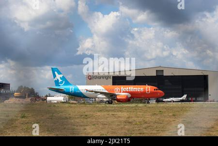 Das erste Flugzeug von Canada Jetlines A320 ist durch den Flughafenzaun im Fokus, während es auf einem Flughafen parkt und auf seinen ersten kommerziellen Service-Flug wartet. Stockfoto