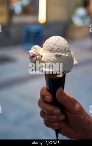 Frau hält Obst veganes Eis in Waffelkegel auf der Straße, Nahaufnahme Stockfoto
