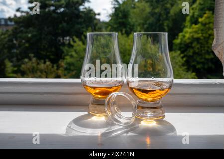 Zwei Gläser Single Malt Scotch Whisky, serviert auf einer alten Fensterbank im Scottisch House, mit Blick auf den alten Teil von Edinburgh, Schottland, Großbritannien, mit einem Schluck Whisky Stockfoto