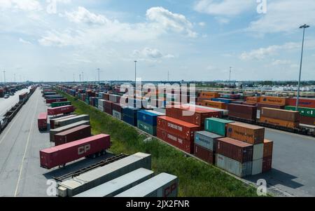 Ein Luftfoto über einem riesigen Containerterminal. An einem teilweise bewölkten, sonnigen Tag. Stockfoto