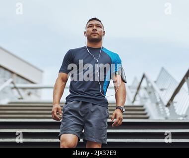 So bereit dafür. Low-Angle-Aufnahme eines männlichen Läufers, der auf einer Treppe in der Stadt steht. Stockfoto