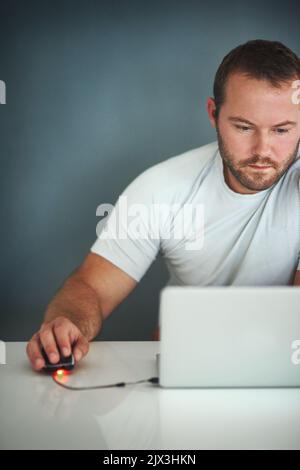 Hes ging zum Bloggen. Ein junger Mann, der an seinem Laptop arbeitete. Stockfoto