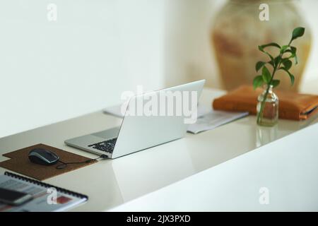 Alles, was Sie brauchen, um einen Blog zu starten. Ein Laptop auf einem Schreibtisch in einem kreativen Geschäftsraum. Stockfoto