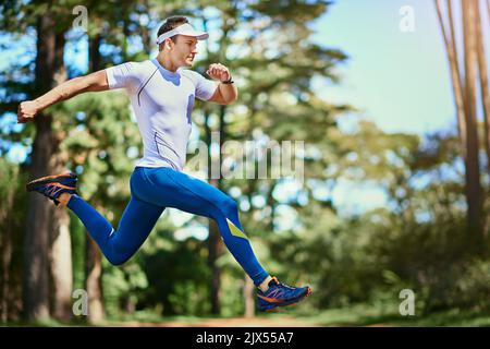 Wenn deine Beine müde werden, Lauf mit deinem Herzen. Ein junger Mann, der auf einem Naturlehrpfad läuft. Stockfoto