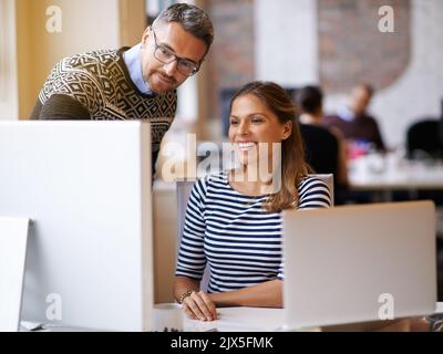 Spielen mit verschiedenen Designs. Zwei Designer arbeiten zusammen an einem Computer. Stockfoto