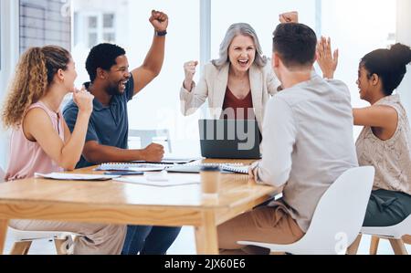 Geschäftsleute feiern das Ziel, das Ziel und den Erfolg des Meetings, während sie während eines Meetings in einem Büro jubeln. Werbe- und Marketing-Team freut sich über Stockfoto