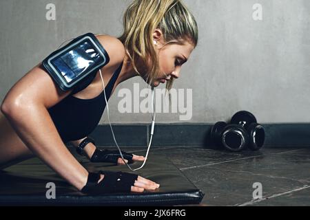 Ausdauer bedeutet niemals aufgeben. Eine junge Frau macht Liegestütze. Stockfoto