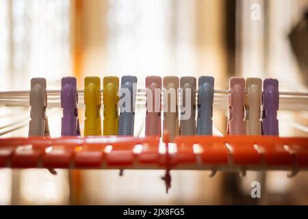 Mehrfarbige Wäscheklammer/Kleiderbügel auf einem Standfuß für die Wäschetrocknung. Stockfoto