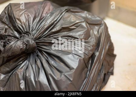 Ein verknoteter Müll/Müllsack, der mit Haushaltsabfall gefüllt ist. Stockfoto