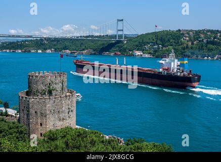 Ein Ozeandampfer segelt entlang der Bosporus-Straße an der Rumeli Hisari (Festung) vorbei zur Fatih-Sultan-Mehmet-Brücke in Istanbul in der Türkei. Stockfoto