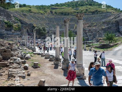 Touristen spazieren entlang der Harbour Street, nachdem sie das römische Theater in der antiken Stadt Ephesus in der Türkei besucht haben. Stockfoto