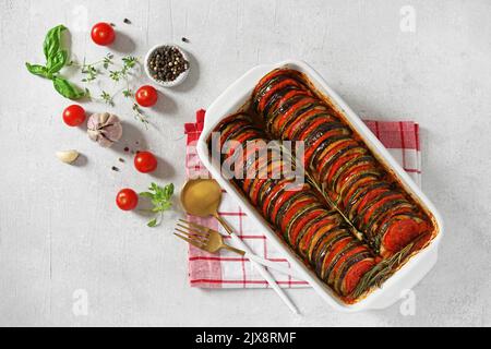 Ratatouille in quadratischer Form, Gemüseeintopf aus geschnittenen Auberginen, Zucchini und Tomaten mit Sauce, Gewürze fast, französische Küche, flat lay Stockfoto