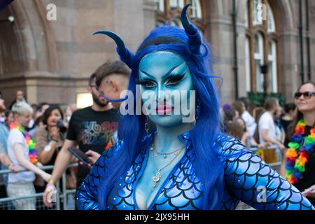 Manchester Pride Parade. Frau im blauen Schlangenkostüm. Themenmarsch für den Frieden. Stockfoto