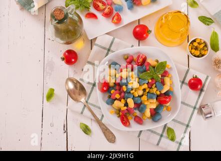 Farbige Gnocchi mit Gemüse und süßem Mais. Stockfoto