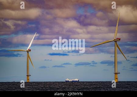 Dateifoto vom 26/07/22, auf dem ein Schiff an Windturbinen bei RWE's Gwynt y Mor vorbeifährt, wie die Handelsgesellschaft, die früher als Oil and Gas UK bekannt war, eine „rasche Expansion des Offshore-Windes“ gefordert hat, da die Energiepreise auf der ganzen Welt steigen. Stockfoto