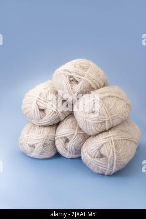 Gruppe von grauer Wolle aus Garn und Faden auf blauem Hintergrund. Stricken, Hobby, Winter. Speicherplatz kopieren Stockfoto