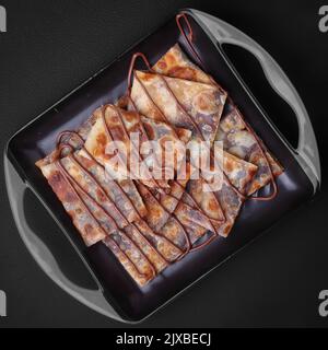 Geröstete Tandoori-Roti mit Schokolade in einem Gericht dunklen Hintergrund Studiofotografie arrangieren Stockfoto