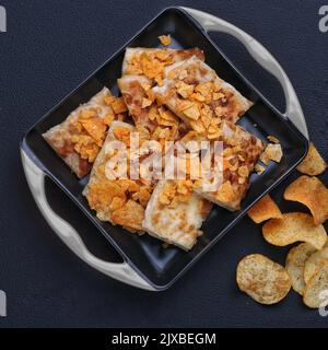 Geröstete Tandoori-Roti mit Snacks in einem Gericht dunklen Hintergrund Studiofotografie arrangieren Stockfoto