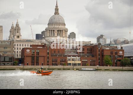 St. Pauls Cathedral, London, England. Ein RNLI-Rettungsboot mit starren Schlauchbooten auf der Themse. Stockfoto