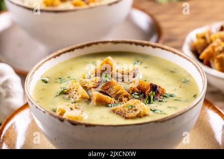 Knoblauchsahnesuppe mit Brotcroutons in rustikaler Schüssel - Nahaufnahme. Stockfoto