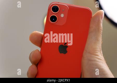 Tjumen, Russland-12. August 2022: IPhone 12 Mini Produkt rot mit Retail-Box, Kauf Konzept Foto, gelber Hintergrund Stockfoto