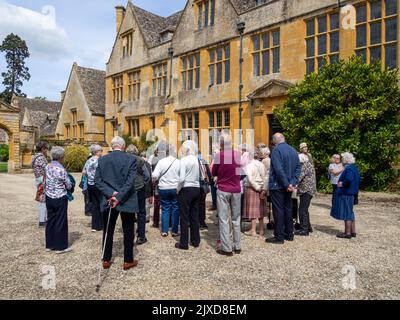 Außenansicht des Stanway House, einem jakobischen Herrenhaus aus dem 16.. Jahrhundert, Stanway, Cotswolds, Gloucestershire; mit einer Gruppe von älteren Besuchern Stockfoto