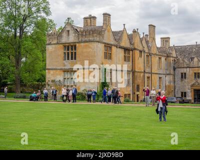 Außenansicht des Stanway House, einem jakobischen Herrenhaus aus dem 16.. Jahrhundert, Stanway, Cotswolds, Gloucestershire; mit einer Gruppe von älteren Besuchern Stockfoto