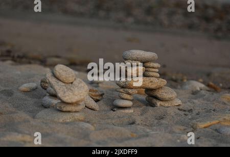 Stein männlichen Steinen Yoga-Meditation am Strand Stockfoto