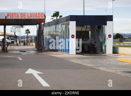 Bild einer Waschstraße neben einem Roboter, der an einer spanischen Tankstelle automatisch Autos von außen reinigt Stockfoto