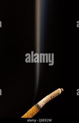 Nahaufnahme eines Räucherstäbchens isoliert auf schwarzem Hintergrund Stockfoto