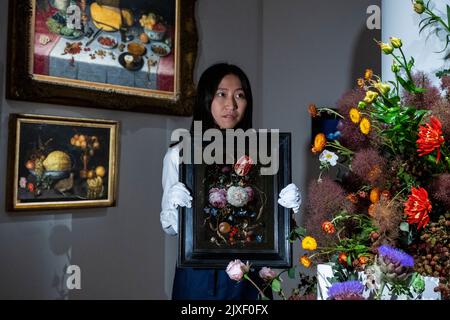 London, Großbritannien. 7. September 2022. Ein Techniker stellt "Stillleben von Blumen in einer Glasvase mit Insekten und Früchten in einer Steinnische" vor, von Jan Davidz De Heem (Est. £1,0 bis 1,5m) bei einer Vorschau auf eine Sammlung von Stillleben alter Meister in Sotheby’s Mayfair Galerien. Die Werke sind Teil des Old Masters-Verkaufs, der am 7. Dezember versteigert wird. Kredit: Stephen Chung / Alamy Live Nachrichten Stockfoto