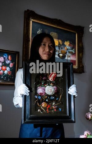 London, Großbritannien. 7. September 2022. Ein Techniker stellt "Stillleben von Blumen in einer Glasvase mit Insekten und Früchten in einer Steinnische" vor, von Jan Davidz De Heem (Est. £1,0 bis 1,5m) bei einer Vorschau auf eine Sammlung von Stillleben alter Meister in Sotheby’s Mayfair Galerien. Die Werke sind Teil des Old Masters-Verkaufs, der am 7. Dezember versteigert wird. Kredit: Stephen Chung / Alamy Live Nachrichten Stockfoto