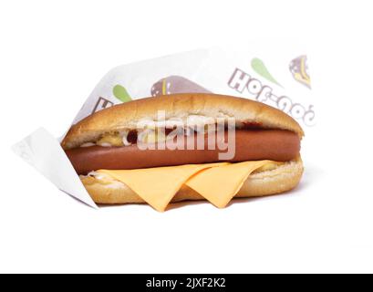 Hotdog mit Cheddar-Käse, isolierter weißer Hintergrund Stockfoto