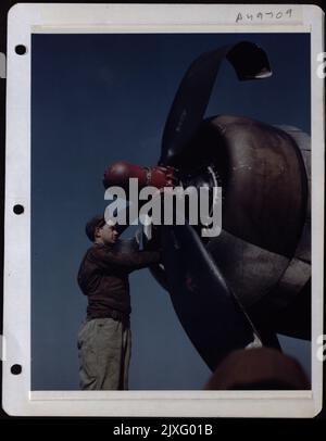 „Little Miss Mischief“ Eine Boeing B-17 der 8. AF landte Nach Einer Mission über Deutschland Auf dem Heimatstützpunkt. Cpl. Irving Flechner aus Bronx, N.Y., Bergungsmechaniker, strips the Engine of Usable Parts. Stockfoto