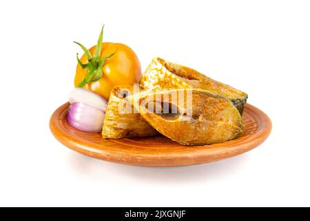 Rohe, ungekochte Hilsa- oder Terubok-Stücke auf einer Tonplatte mit Gewürzpulver, Tpmato und Zwiebeln. Ein beliebtes bengalisches Gericht. Nationalfisch von Bangladesch. Padma i. Stockfoto