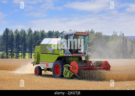 Farmer Ernte reifen Weizenfeld mit Claas Dominator 48S Mähdrescher an einem sonnigen Tag im August. Salo, Finnland. 27. August 2022. Stockfoto