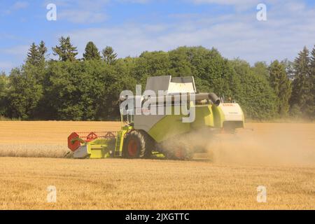 Landwirt im Feld Ernte reifen Weizen mit Claas Tucano 570 Mähdrescher an einem sonnigen Tag im August. Rückansicht. Salo, Finnland. 28. August 2022. Stockfoto