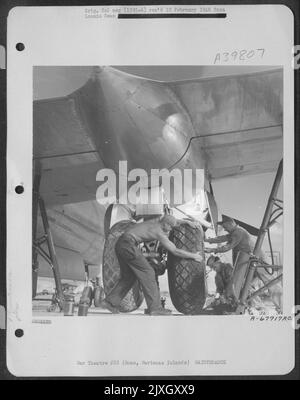 Bodenbesatzungsmitglieder wechseln eines der riesigen Räder auf Einer Boeing B-29 „Superfortress“ in North Field, Guam, Marianas Islands. 7 Mai 1945. Stockfoto