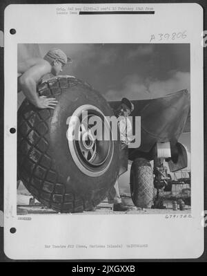 Bodenbesatzungsmitglieder wechseln eines der riesigen Räder auf Einer Boeing B-29 „Superfortress“ in North Field, Guam, Marianas Islands. 7 Mai 1945. Stockfoto