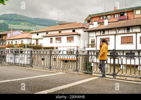 Frau schaut in die alten baskischen Häuser in Orozko Stockfoto