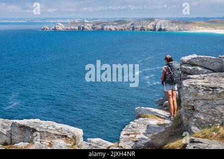 Junge Rucksacktouristen, die von den Klippen aus über das Meer blicken Stockfoto
